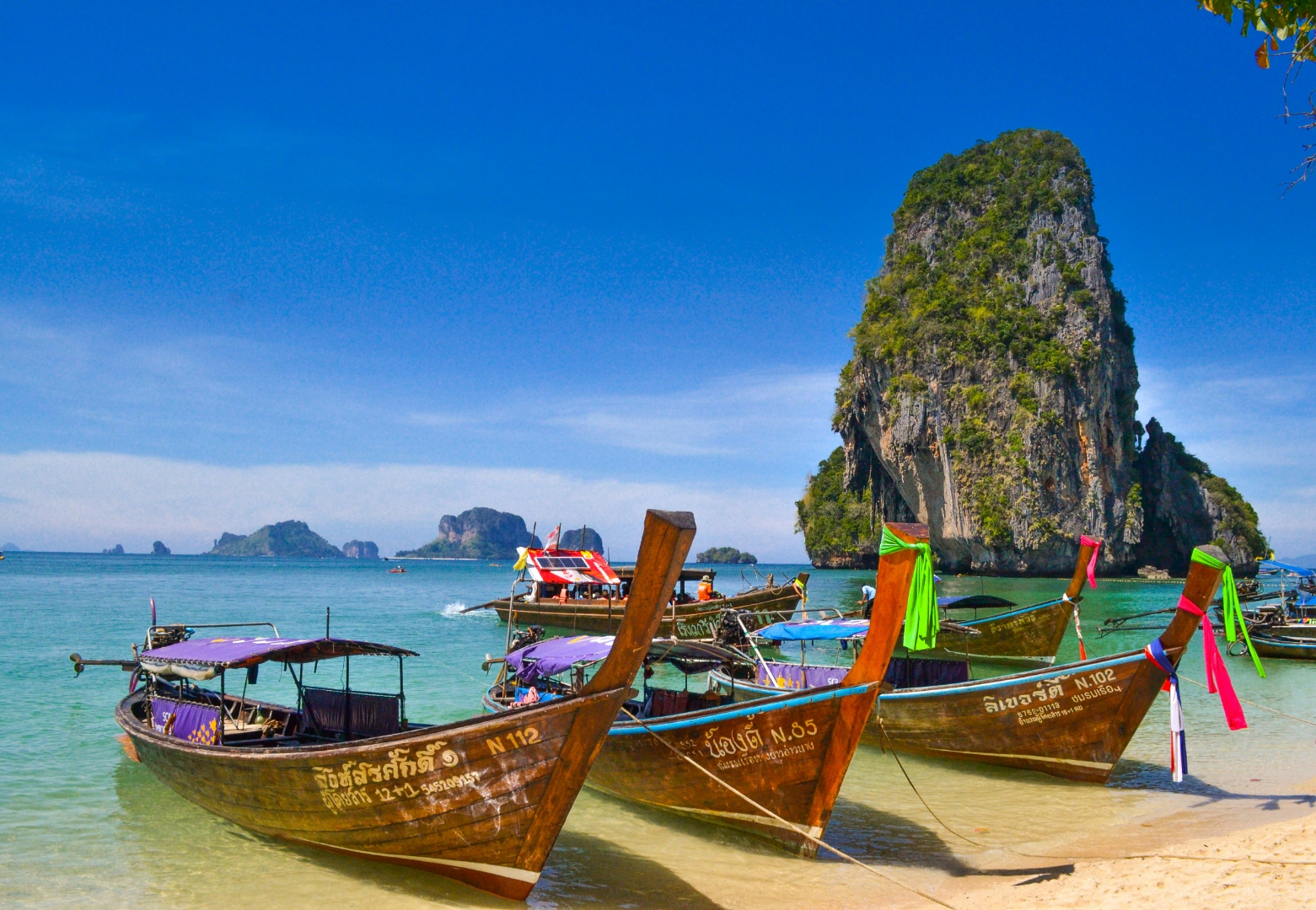 Longtail boats on turquoise water in Krabi, Thailand golf tours Southeast Asia